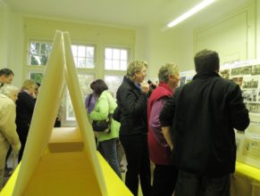 Návštěvníci prohlížející si fotografie obce.