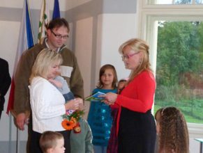 Eva Bittnerová předávající květinu a dárek manželům Kosinkovým, Ivaně a Miroslavovi, se synem Jakubem narozeným 3.6.2011.